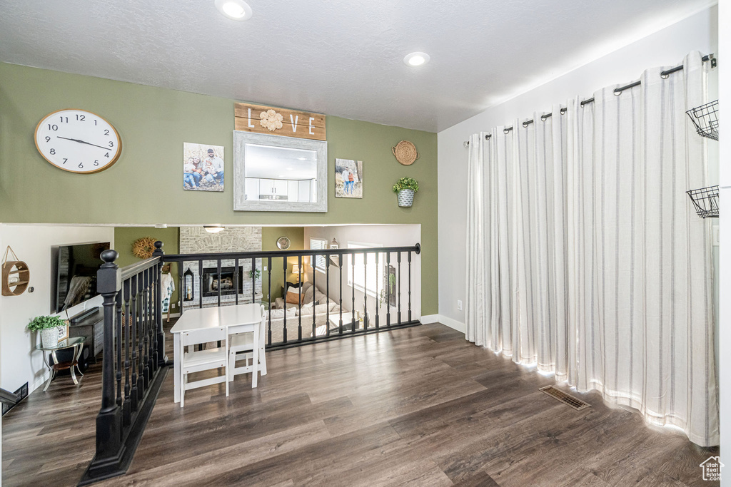 Hall with wood finished floors, recessed lighting, and an upstairs landing