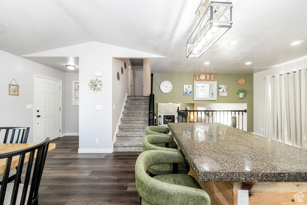 Dining space featuring dark wood finished floors, recessed lighting, and vaulted ceiling