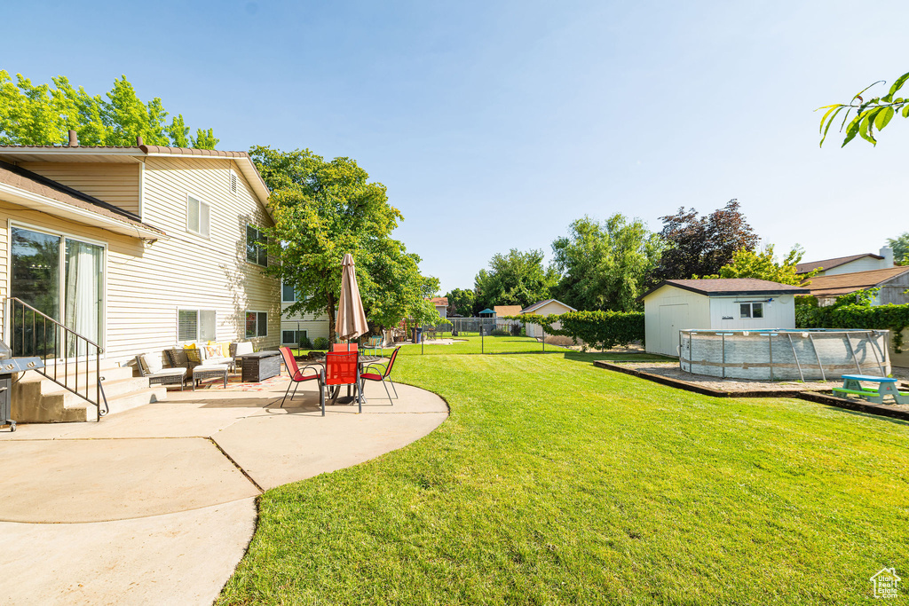 View of yard featuring a patio, an outdoor living space, and a storage shed