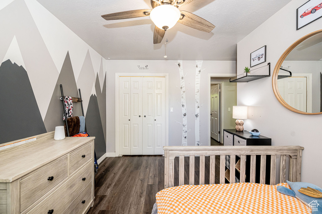 Bedroom with dark wood finished floors, a closet, and a ceiling fan