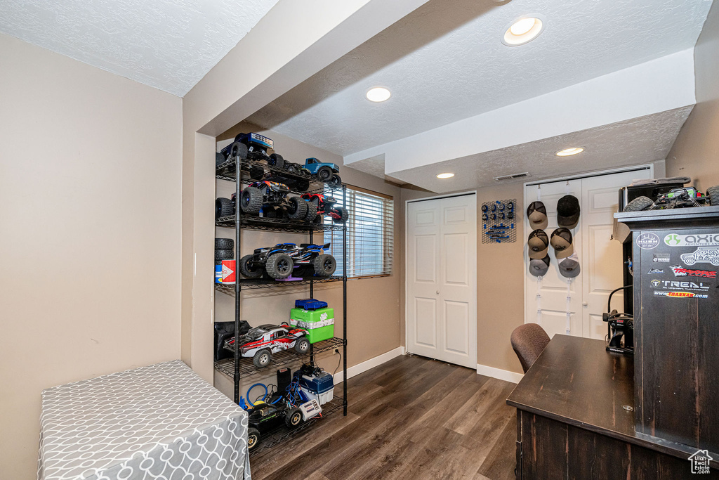 Home office with dark wood finished floors, a textured ceiling, and recessed lighting