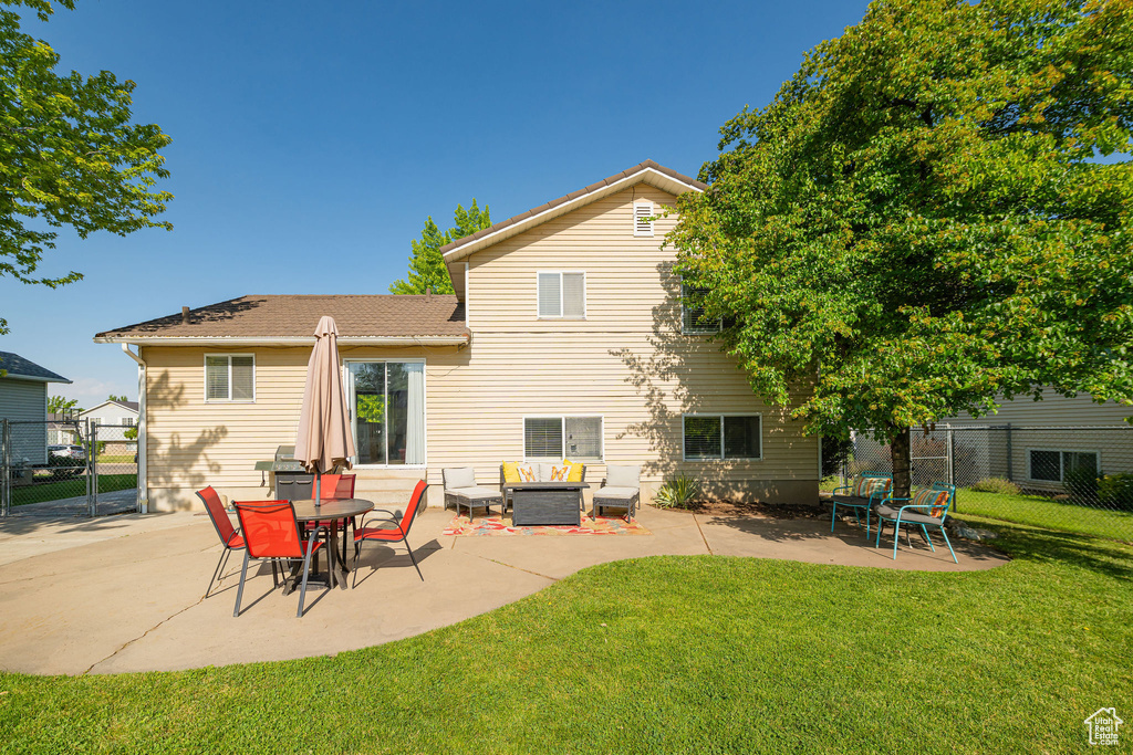Rear view of property with a gate, a patio area, and outdoor lounge area