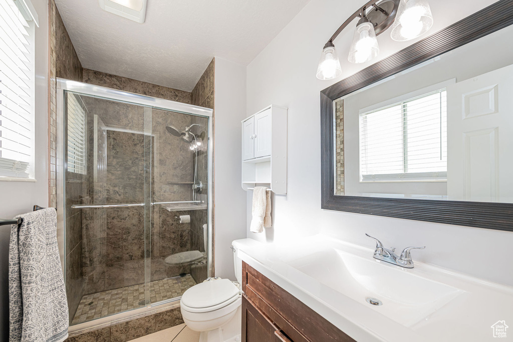 Full bathroom featuring vanity, a shower stall, and tile patterned flooring