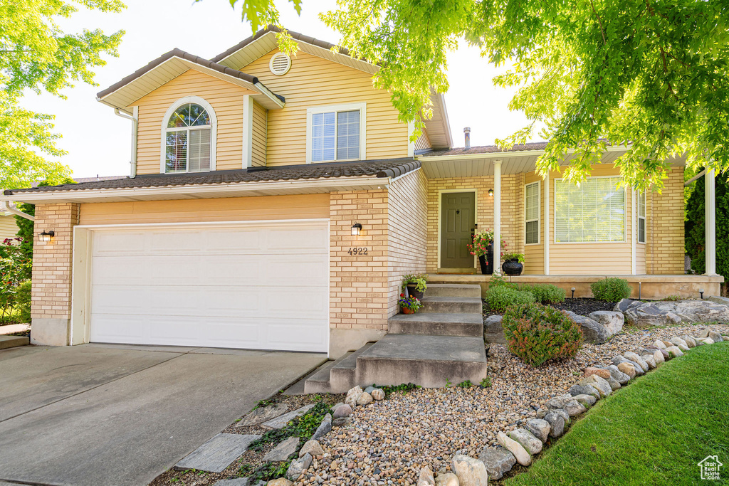 Traditional-style house featuring brick siding, an attached garage, and concrete driveway