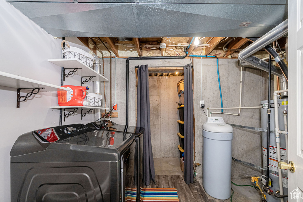 Washroom featuring gas water heater, separate washer and dryer, and wood finished floors