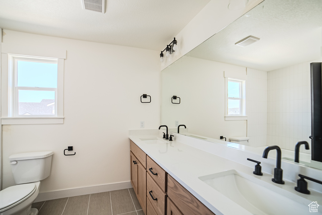 Full bath featuring toilet and double vanity