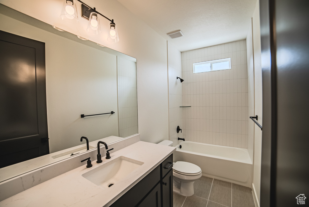 Full bath with vanity, tile patterned flooring, and shower / tub combination