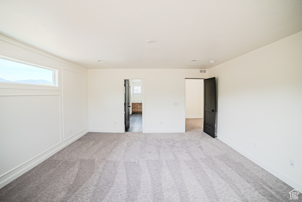 Unfurnished bedroom with multiple windows and light colored carpet
