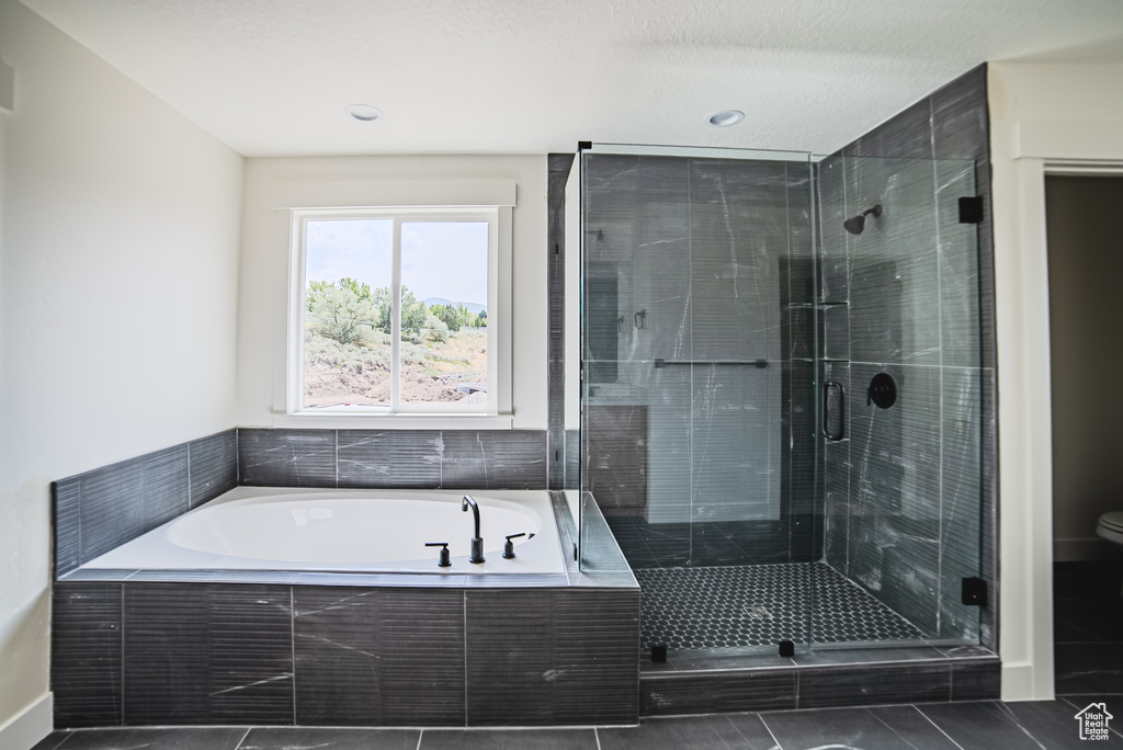 Full bath featuring a garden tub, a shower stall, and tile patterned floors