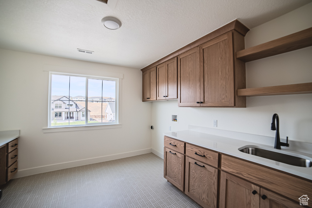 Kitchen featuring open shelves, light countertops, and brown cabinets