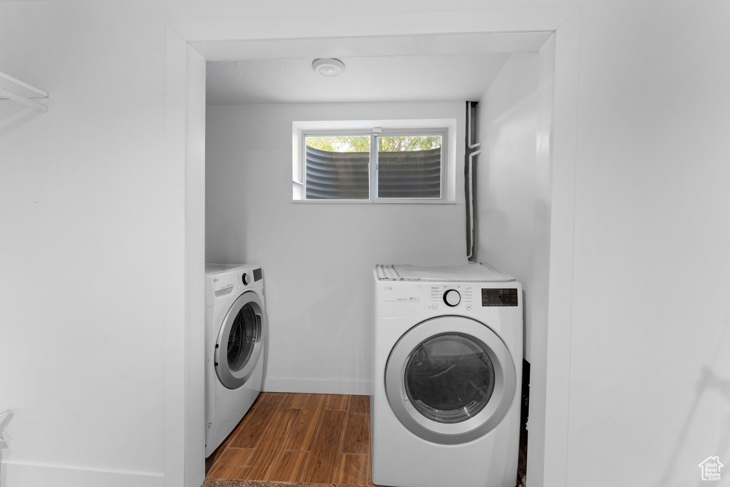 Laundry area featuring washer and clothes dryer and dark wood-type flooring
