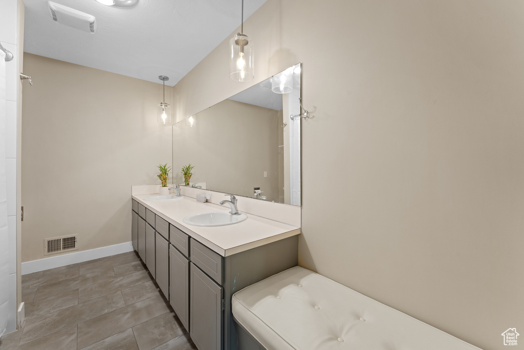 Bathroom with double vanity and baseboards