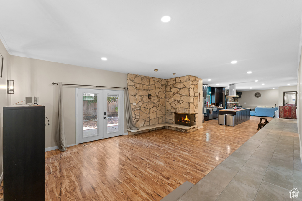 Living room featuring recessed lighting, french doors, a fireplace, and light wood finished floors