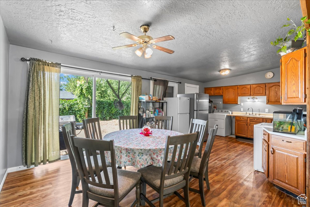 Dining space featuring washer / dryer, dark wood finished floors, a ceiling fan, and a textured ceiling