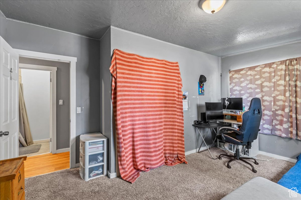 Office space with a textured ceiling and carpet flooring