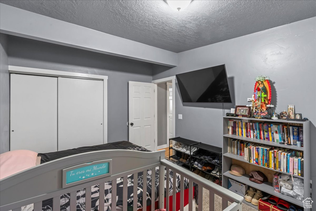 Bedroom featuring a textured ceiling and a closet