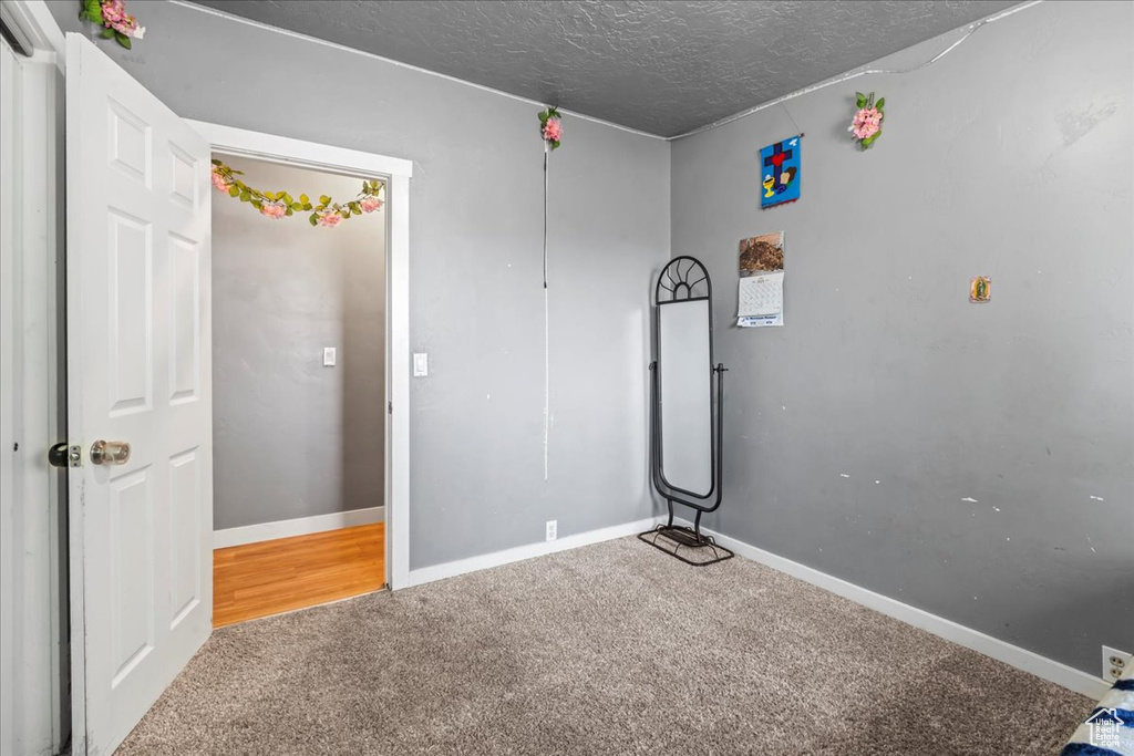 Unfurnished bedroom with carpet flooring and a textured ceiling