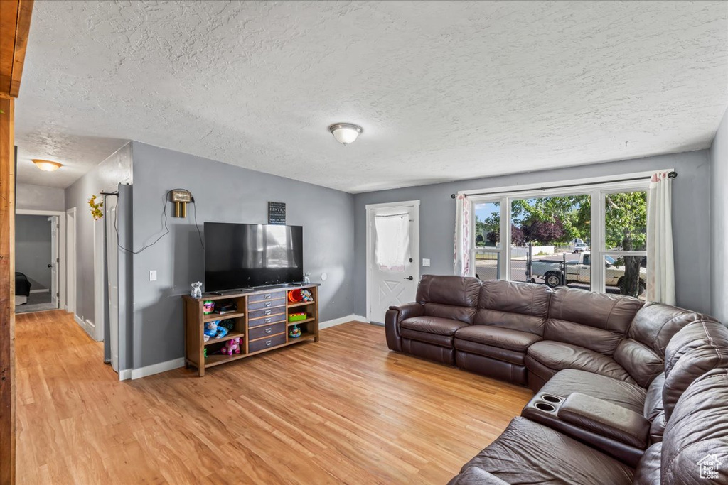 Living area featuring light wood-style flooring and a textured ceiling