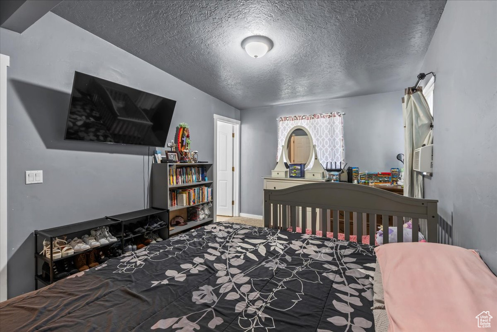 Bedroom with a textured ceiling and carpet