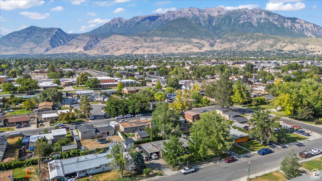 Aerial view of property's location featuring a mountainous background and nearby suburban area