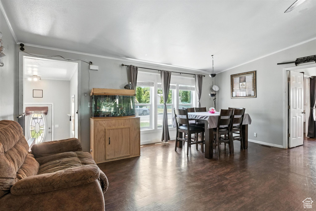 Dining room featuring ornamental molding and dark wood-type flooring