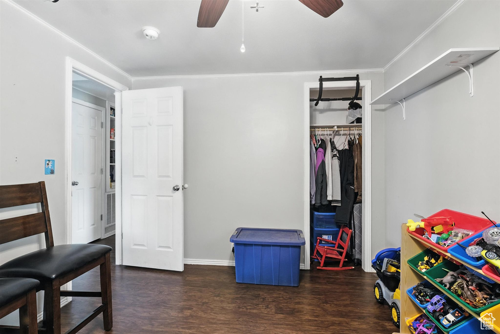 Bedroom with wood finished floors, a closet, ornamental molding, and a ceiling fan