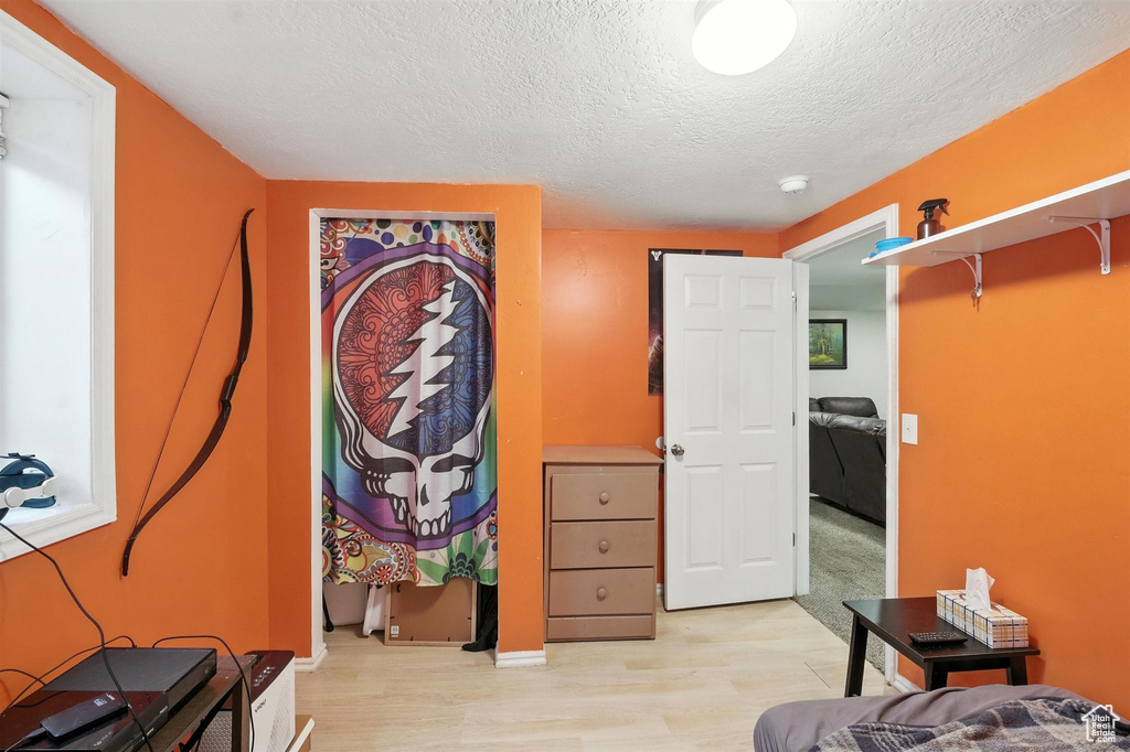 Bedroom featuring a textured ceiling and light wood-style floors
