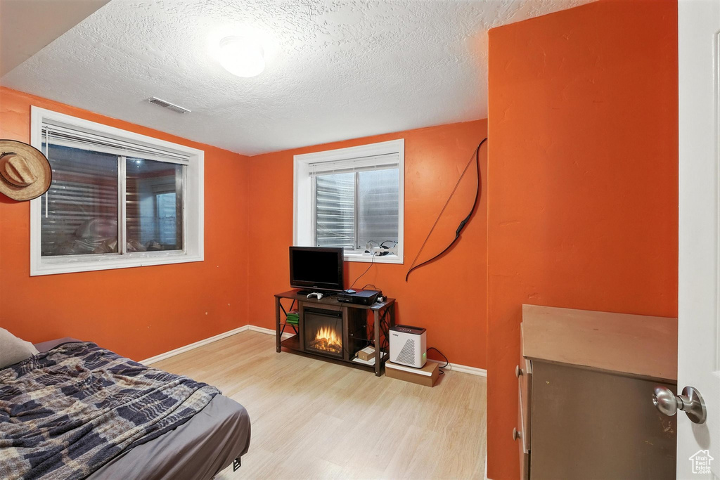 Bedroom featuring light wood finished floors and a textured ceiling