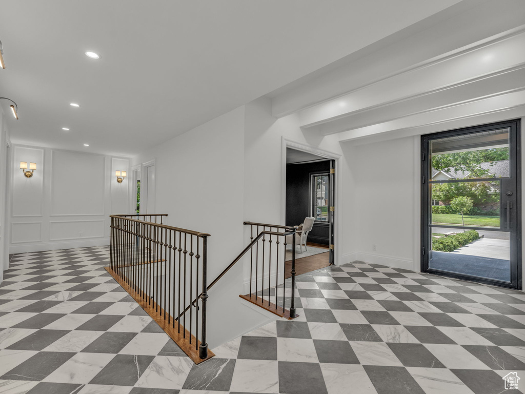 Corridor featuring an upstairs landing, recessed lighting, and a decorative wall