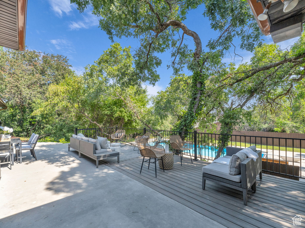 Wooden deck with an outdoor hangout area, a patio area, view of wooded area, and outdoor dining area