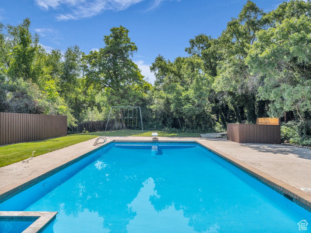 View of pool with a fenced backyard and a diving board