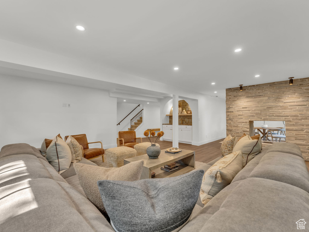 Living area with stairs, recessed lighting, and wood finished floors