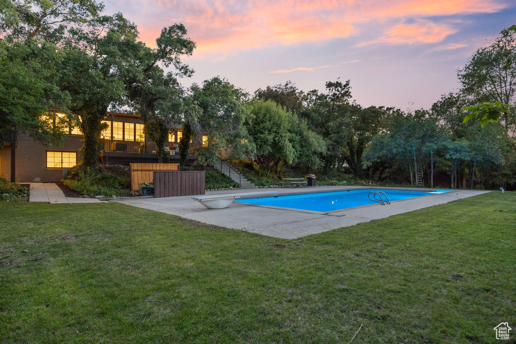 Outdoor pool featuring a yard, stairs, a diving board, and a patio