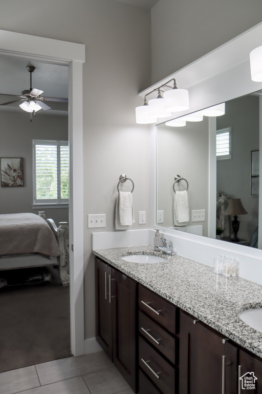 Bathroom featuring ensuite bath, double vanity, and healthy amount of natural light