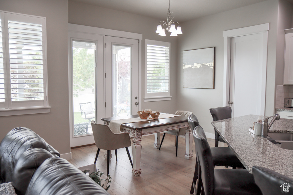 Dining area featuring light wood finished floors and a chandelier
