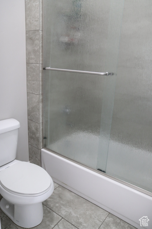 Full bathroom with shower / bath combination with glass door and tile patterned flooring