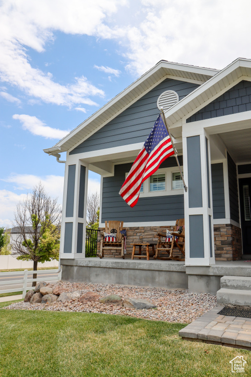 View of side of home featuring a porch and stone siding