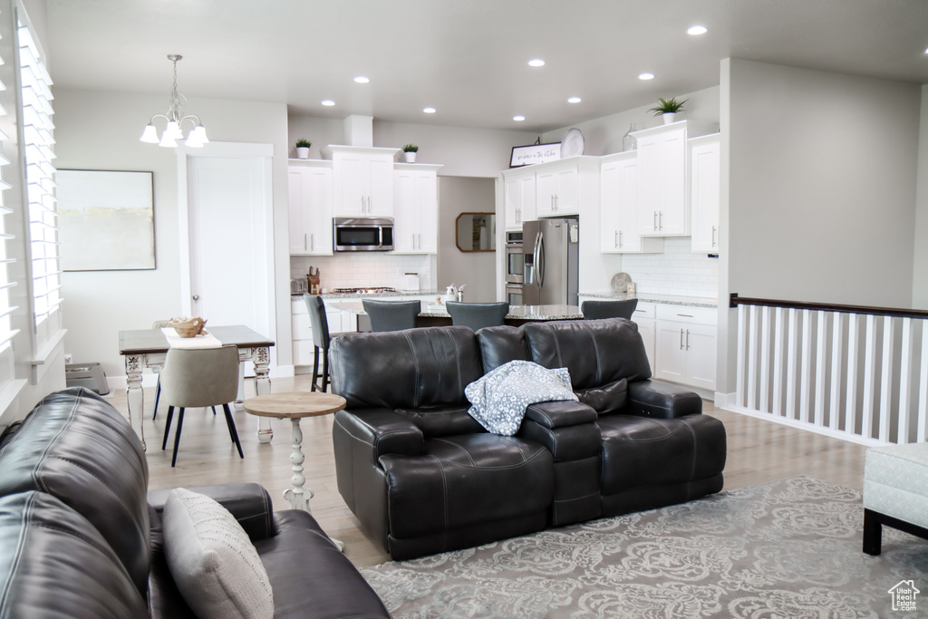 Living area featuring recessed lighting, light wood finished floors, and a chandelier