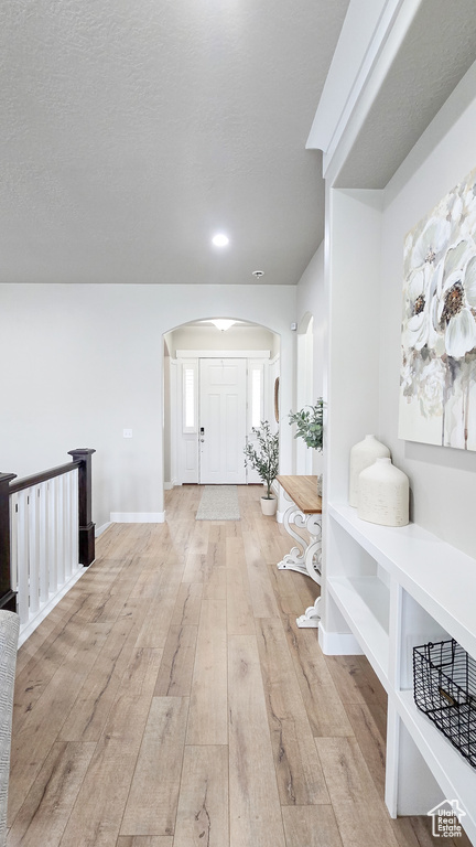 Entryway featuring arched walkways, hardwood / wood-style floors, and recessed lighting