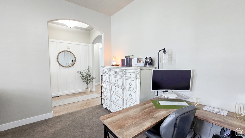 Carpeted office space with arched walkways and baseboards