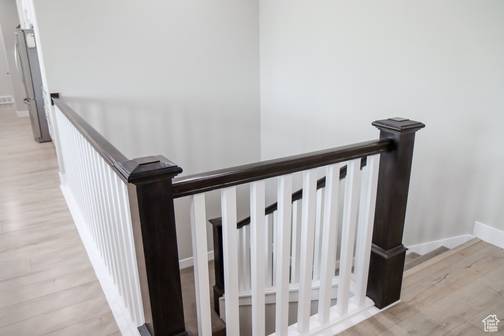 Staircase with wood finished floors and baseboards