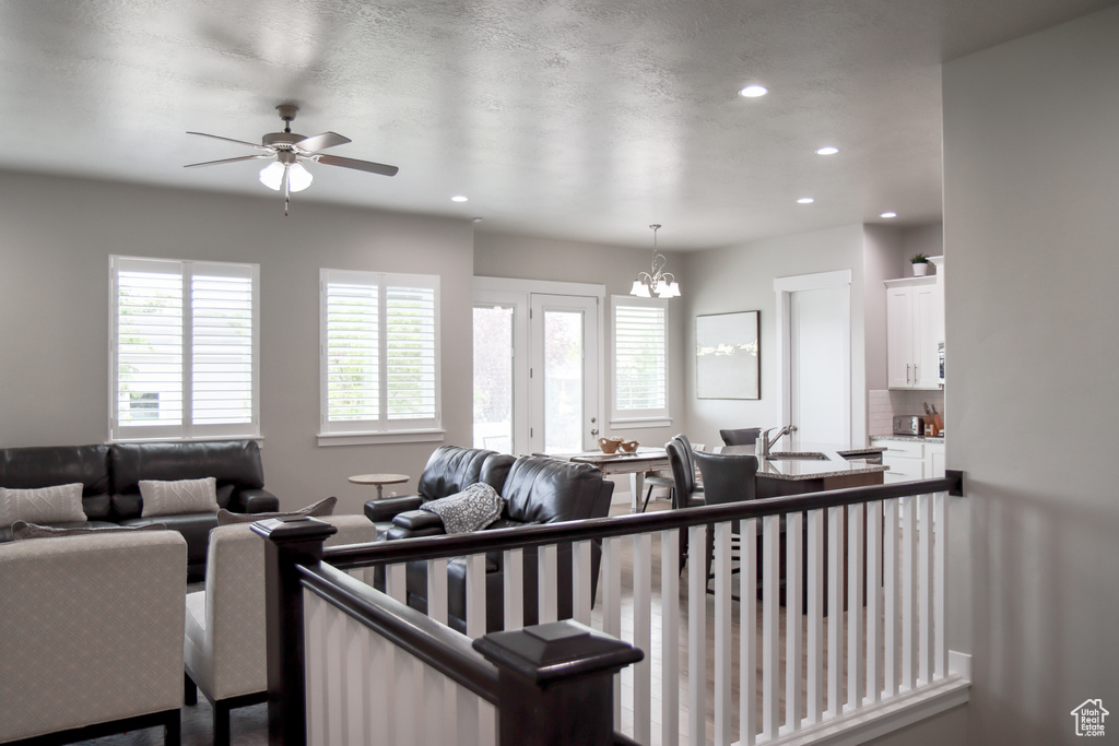Living room with recessed lighting, a ceiling fan, and a chandelier