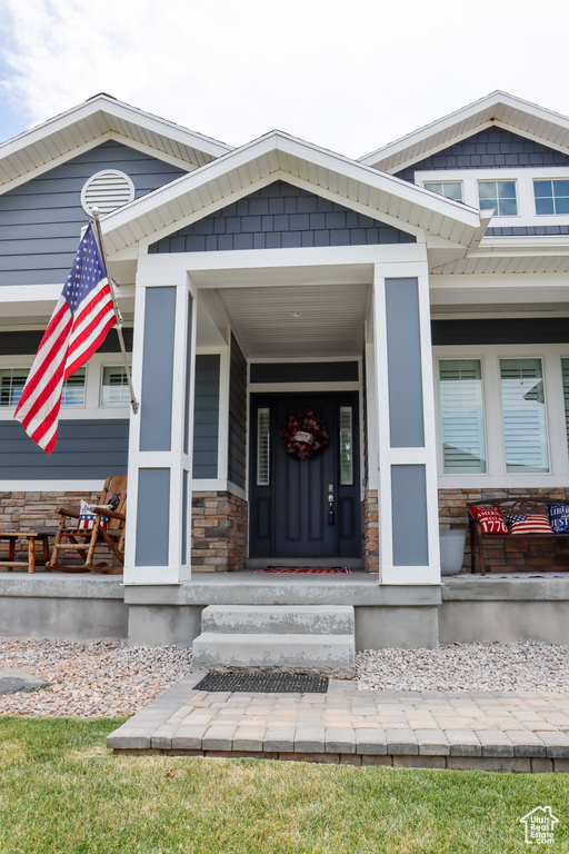 Doorway to property with a porch and stone siding