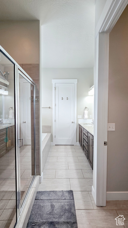 Bathroom with vanity, a shower stall, a bath, and tile patterned floors