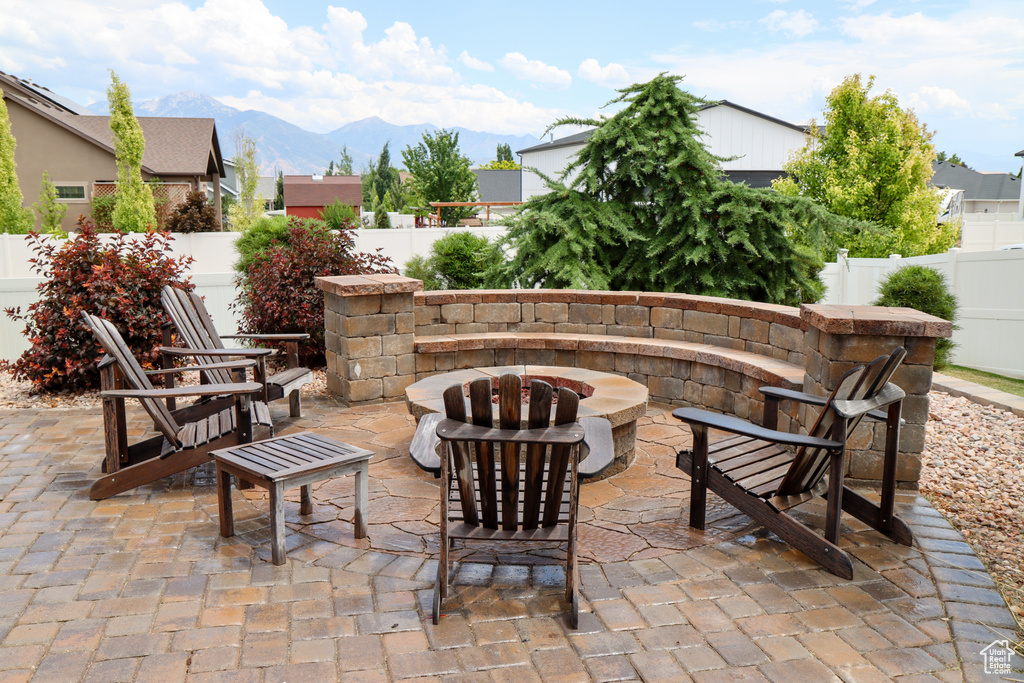 Fenced backyard featuring an outdoor fire pit, a patio, and a mountain view