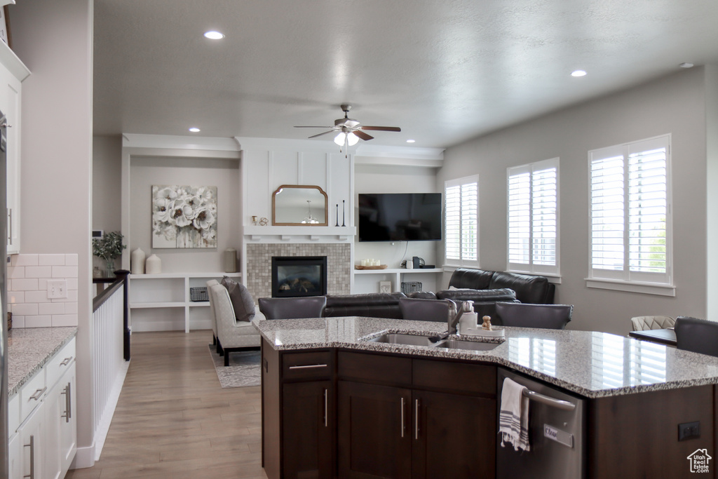 Kitchen featuring stainless steel dishwasher, a fireplace, healthy amount of natural light, a ceiling fan, and recessed lighting