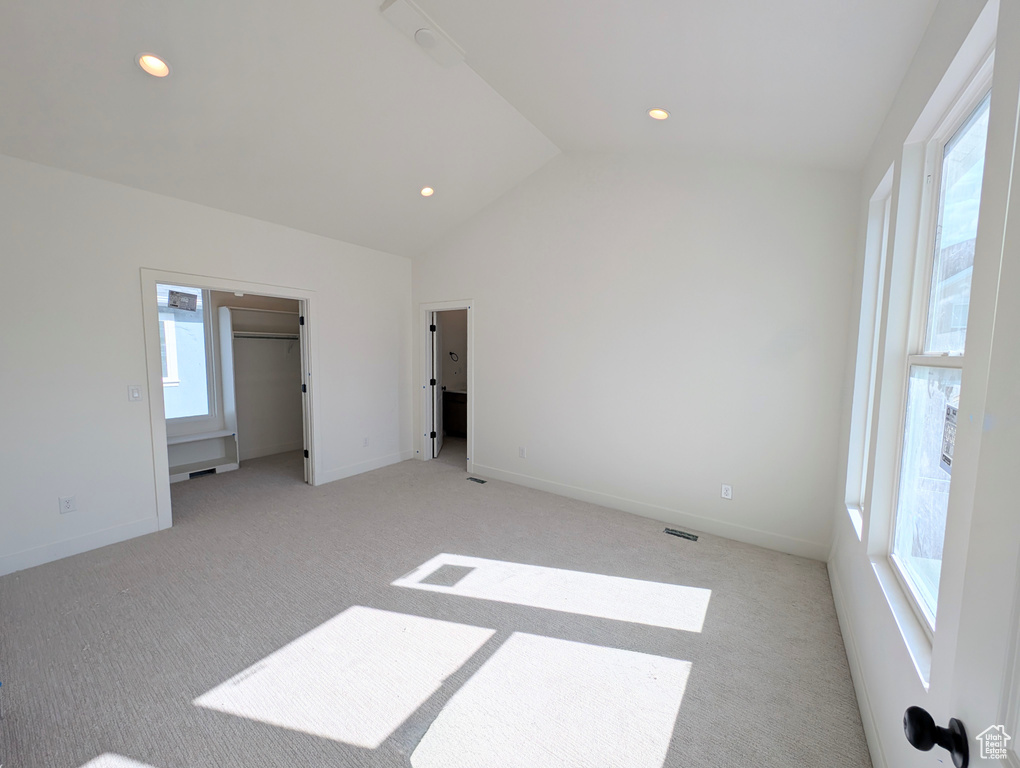 Unfurnished bedroom featuring lofted ceiling, light carpet, and recessed lighting