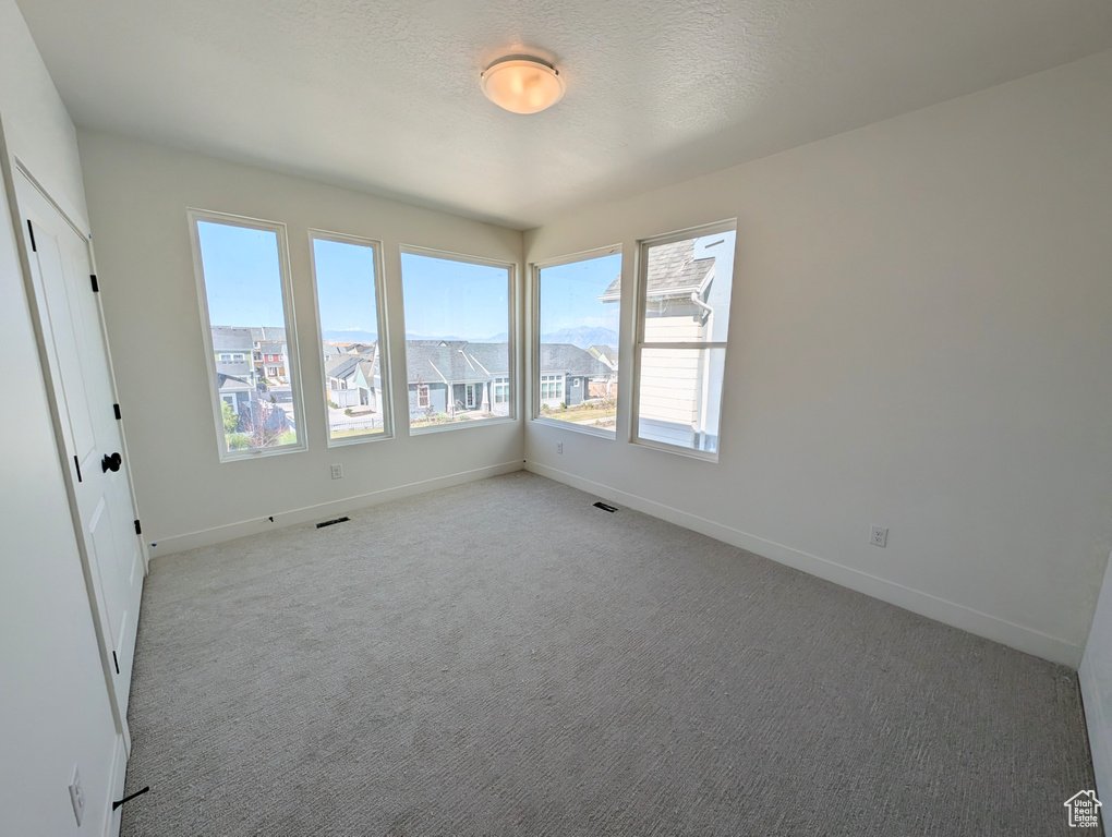 Unfurnished room featuring baseboards and light colored carpet
