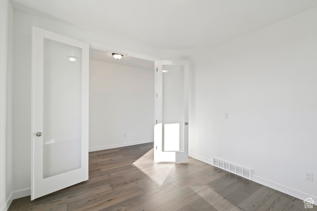 Unfurnished room with wood finished floors and french doors