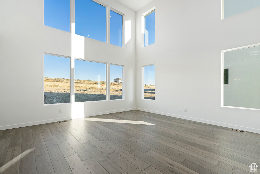 Empty room with a high ceiling and wood finished floors